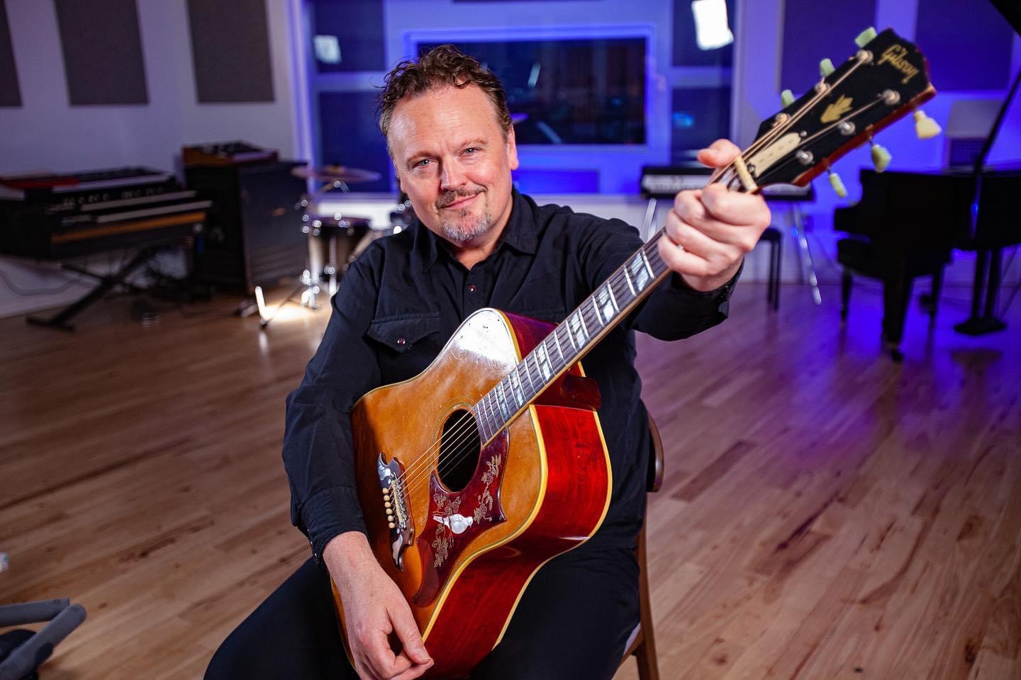 Kevin Hanson in the studio with a Gibson Dove acoustic guitar